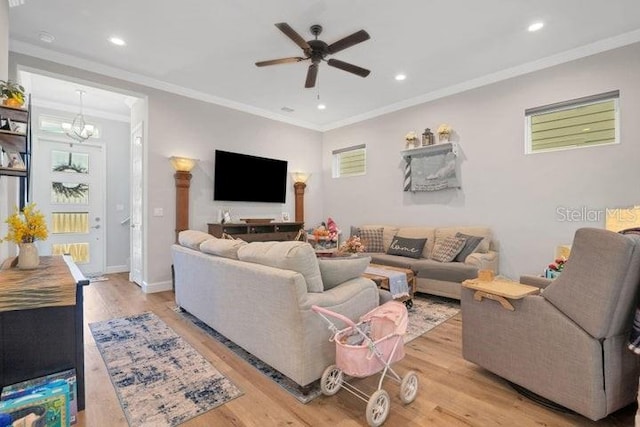 living room with crown molding, light hardwood / wood-style flooring, and ceiling fan with notable chandelier