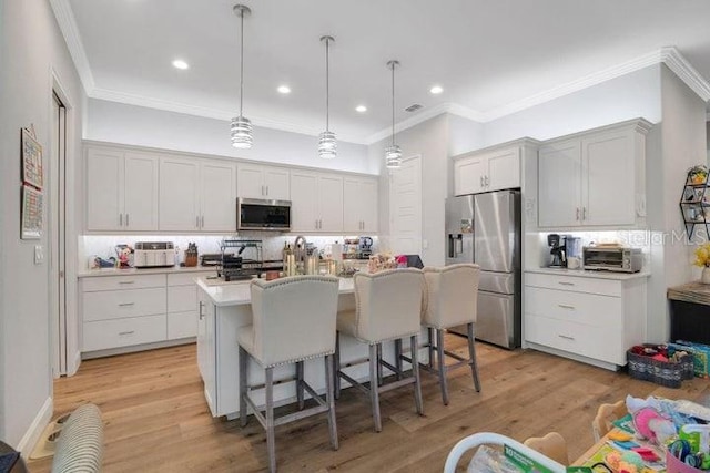 kitchen featuring a center island with sink, light wood-type flooring, a kitchen breakfast bar, pendant lighting, and stainless steel appliances