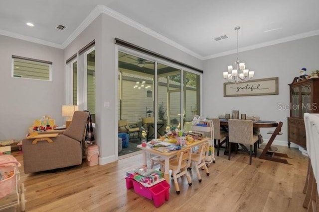 dining room with an inviting chandelier, ornamental molding, and light wood-type flooring