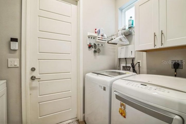 washroom with separate washer and dryer and cabinets