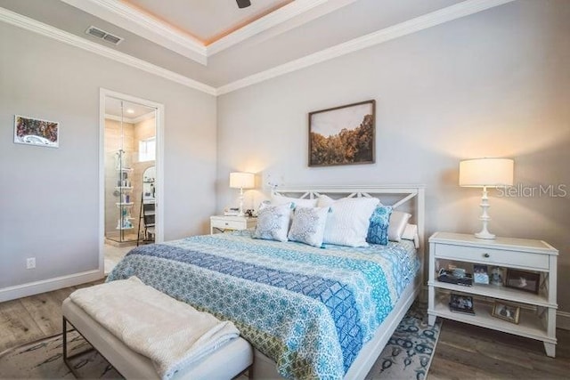 bedroom featuring a tray ceiling, hardwood / wood-style flooring, ornamental molding, and ceiling fan