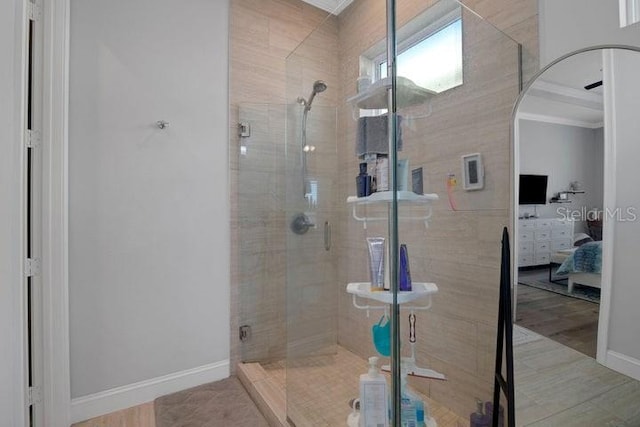 bathroom with a shower with door, wood-type flooring, and ornamental molding