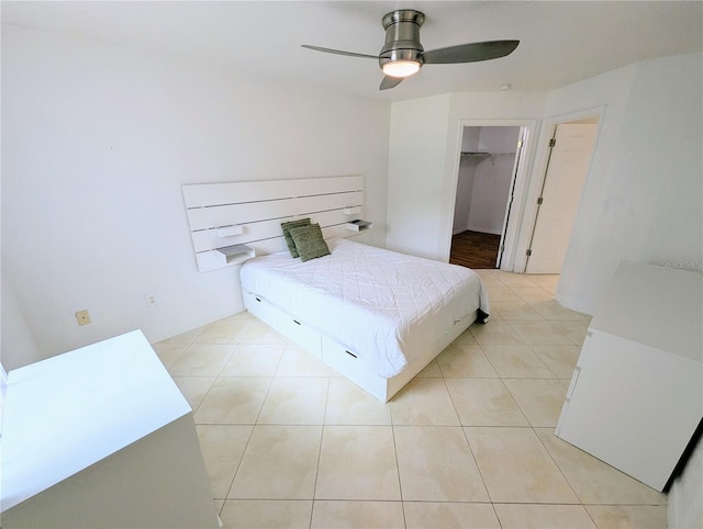 bedroom with light tile patterned floors, a spacious closet, and ceiling fan