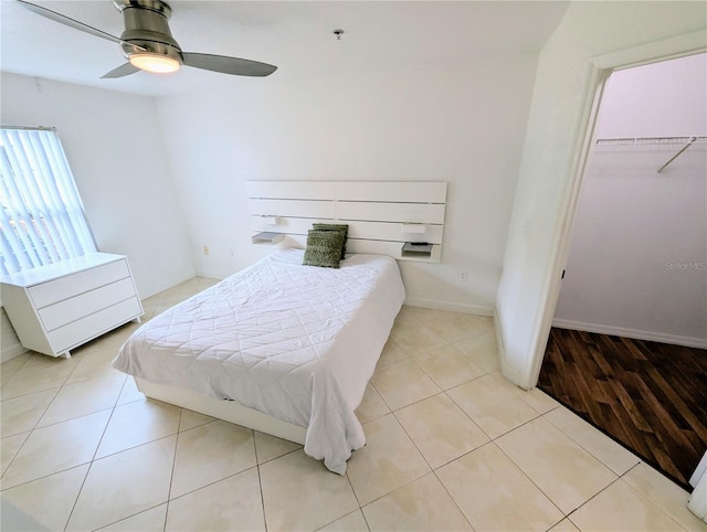 bedroom with light tile patterned flooring, ceiling fan, and a closet