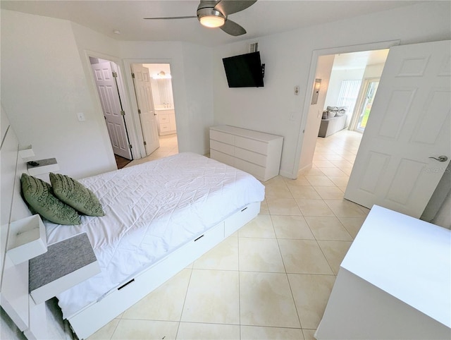 tiled bedroom featuring ceiling fan and ensuite bath