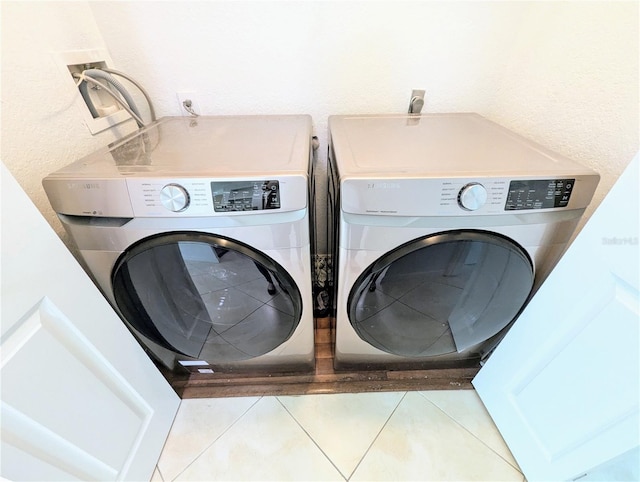 laundry area featuring separate washer and dryer and light tile patterned floors