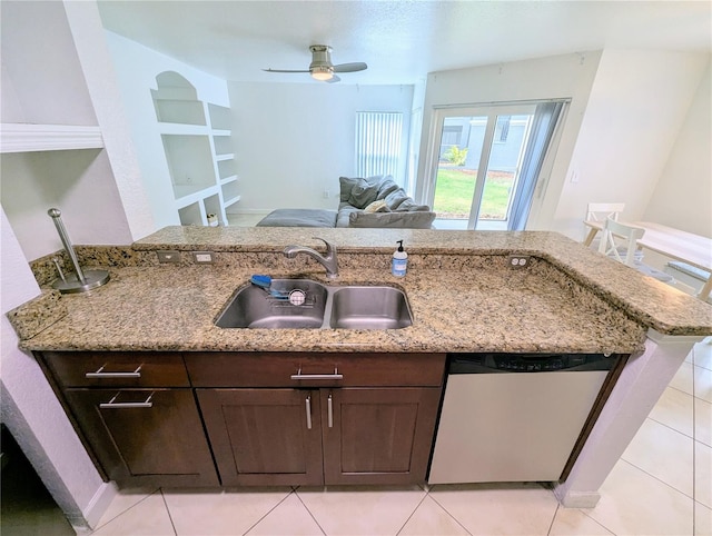 kitchen with dark brown cabinetry, sink, stainless steel dishwasher, kitchen peninsula, and light stone countertops