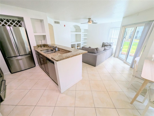 kitchen with stainless steel appliances, light tile patterned flooring, built in shelves, and kitchen peninsula