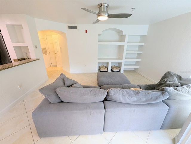 living room featuring light tile patterned floors, built in features, and ceiling fan