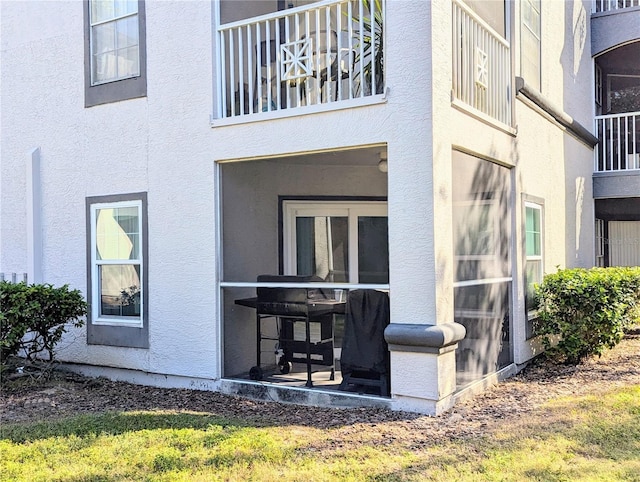 view of exterior entry with a balcony