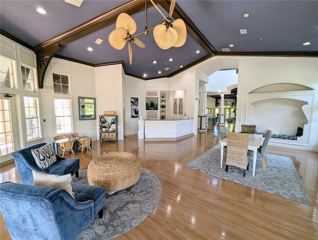 living room with crown molding, wood-type flooring, beam ceiling, and high vaulted ceiling