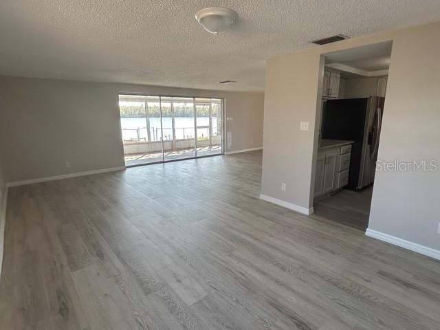 unfurnished room with a textured ceiling and light hardwood / wood-style flooring