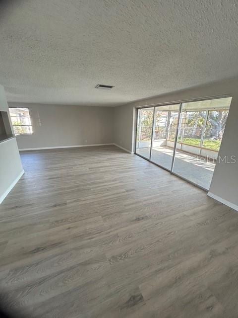 empty room with hardwood / wood-style flooring and a textured ceiling