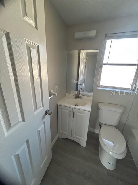 bathroom with vanity, toilet, and hardwood / wood-style floors