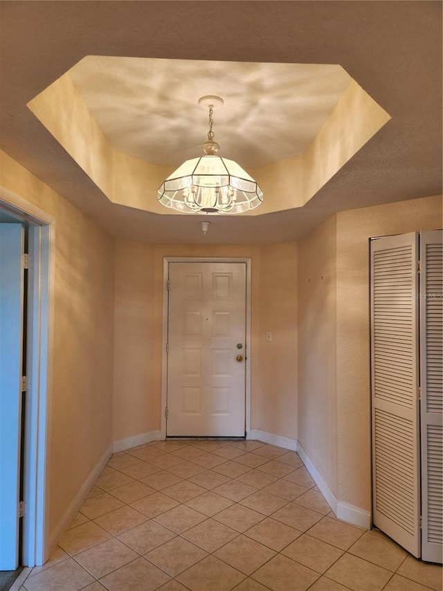 tiled foyer entrance featuring a tray ceiling