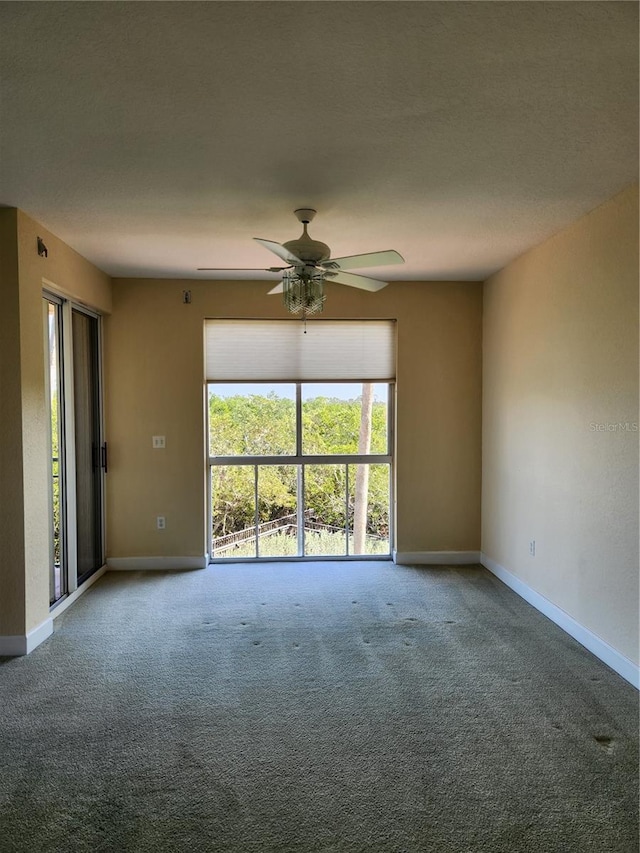 carpeted spare room featuring ceiling fan