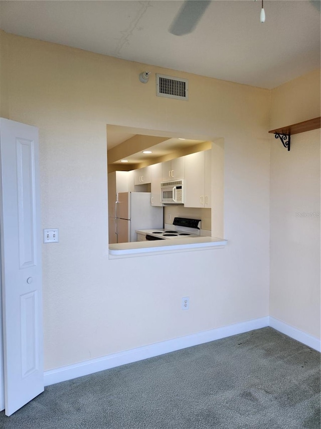 kitchen with white cabinetry, white appliances, kitchen peninsula, and carpet flooring