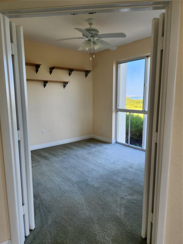 carpeted spare room with ceiling fan