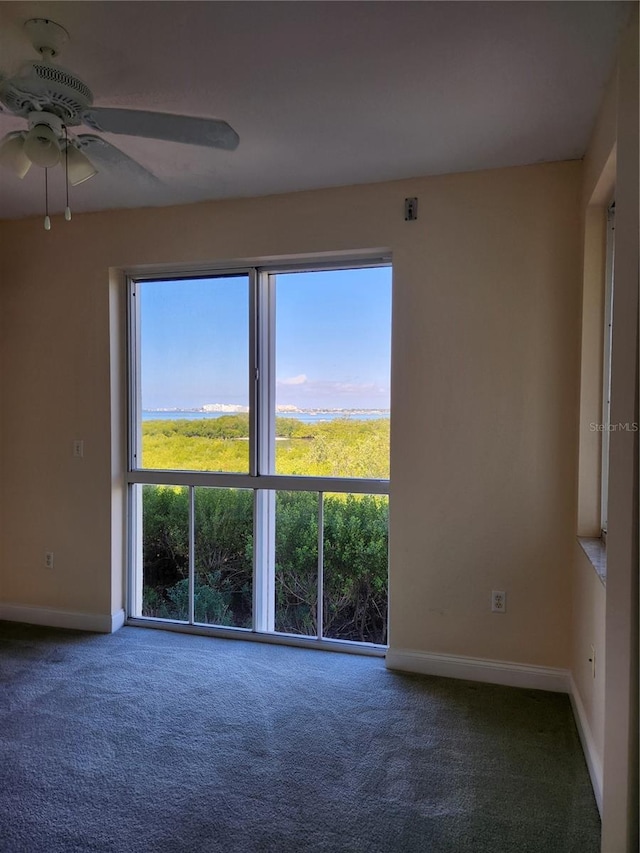 carpeted spare room featuring ceiling fan