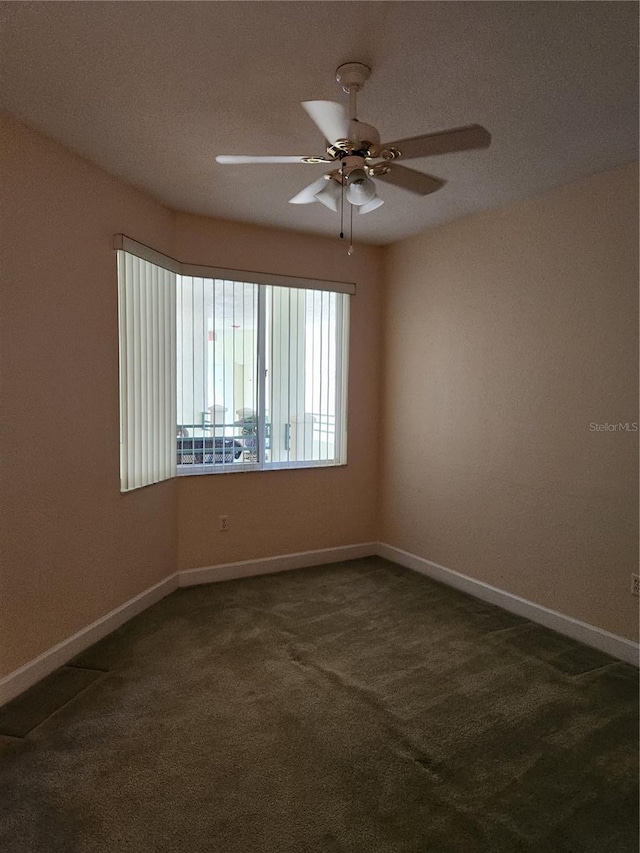 unfurnished room featuring dark colored carpet and ceiling fan