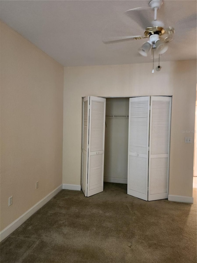 unfurnished bedroom featuring dark carpet, a closet, and ceiling fan