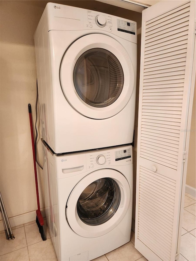 washroom featuring stacked washer / drying machine and light tile patterned floors