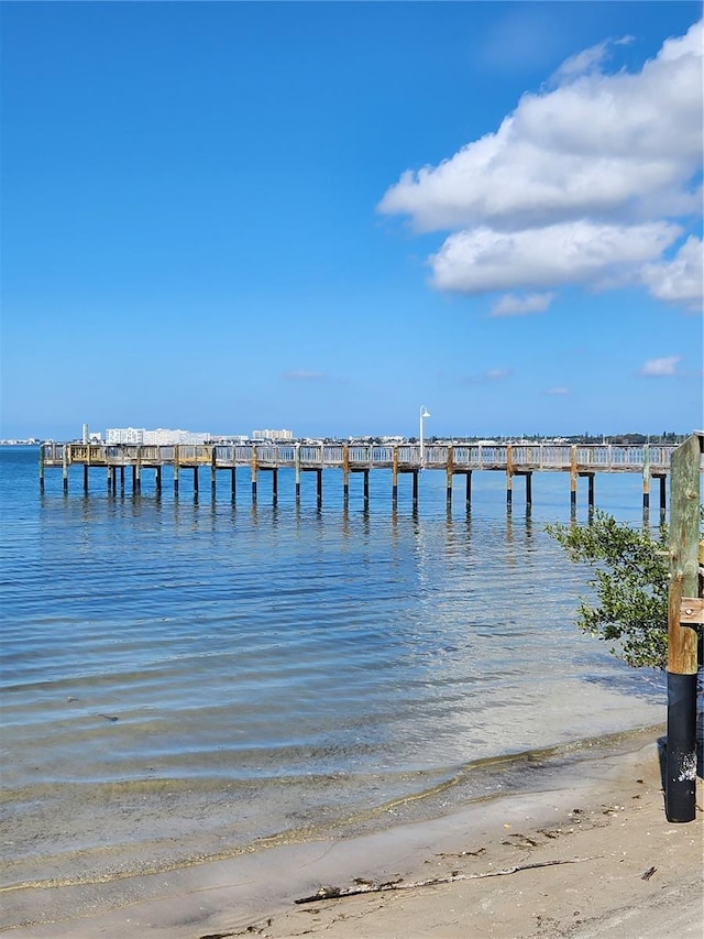 view of dock featuring a water view and a view of the beach