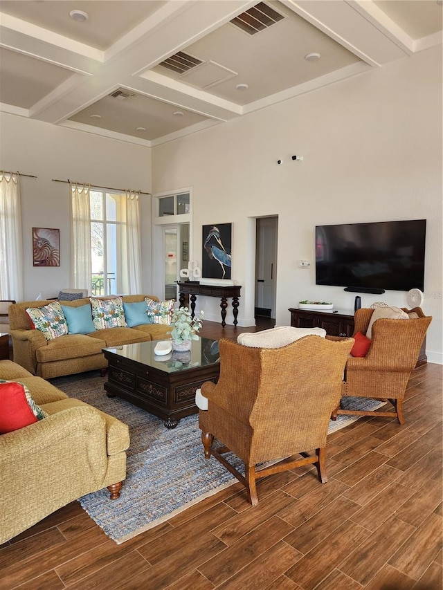 living room featuring coffered ceiling, beam ceiling, and a high ceiling