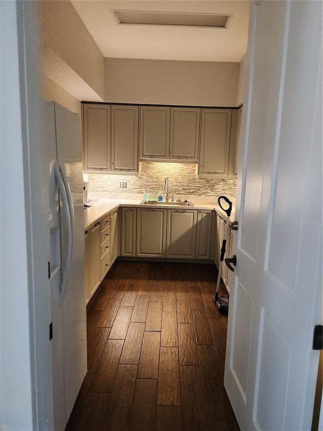 kitchen featuring dark hardwood / wood-style flooring, white refrigerator with ice dispenser, sink, and decorative backsplash