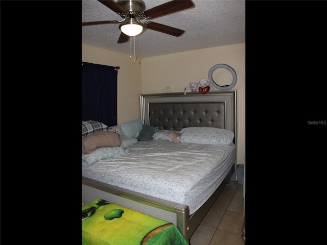 tiled bedroom featuring ceiling fan and a textured ceiling