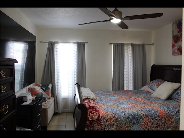 tiled bedroom featuring a textured ceiling and ceiling fan