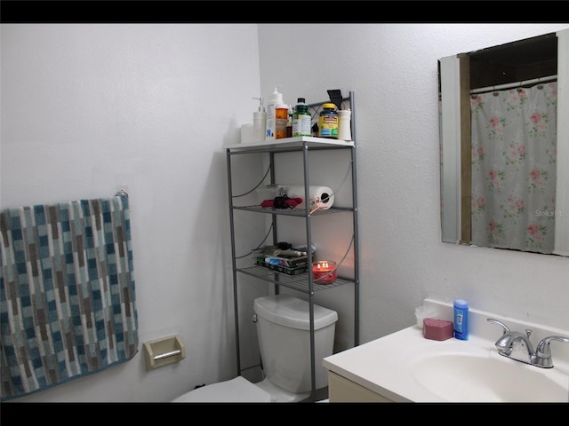 bathroom with vanity, walk in shower, and toilet