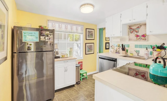 kitchen featuring sink, backsplash, white cabinets, and appliances with stainless steel finishes