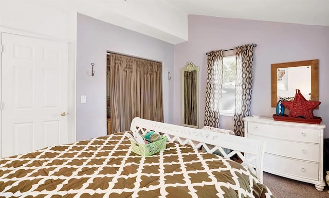 bedroom with lofted ceiling, a closet, and carpet flooring