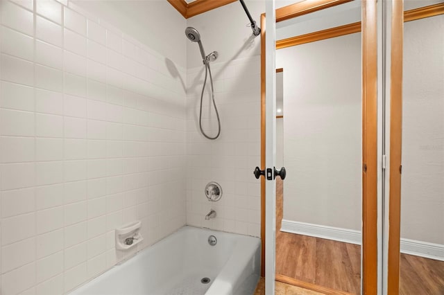 bathroom with hardwood / wood-style flooring and tiled shower / bath combo