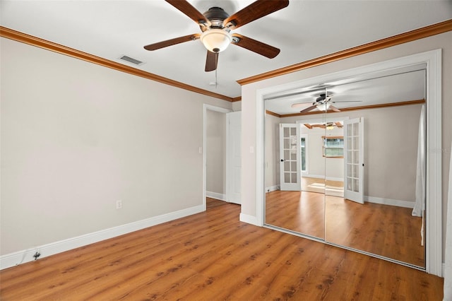 spare room featuring french doors, ceiling fan, crown molding, and light hardwood / wood-style floors