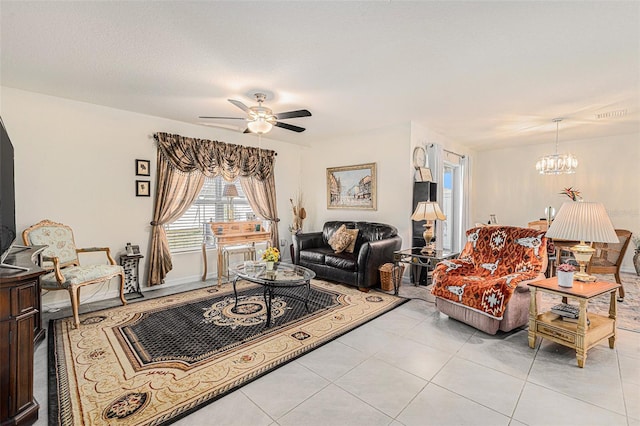 tiled living room featuring ceiling fan with notable chandelier and a textured ceiling