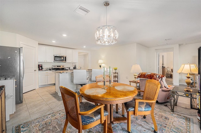 dining area with light tile patterned floors and an inviting chandelier