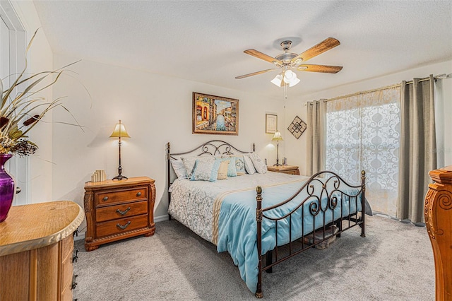 bedroom with ceiling fan, light colored carpet, and a textured ceiling