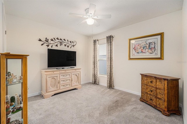 carpeted bedroom featuring ceiling fan and a textured ceiling