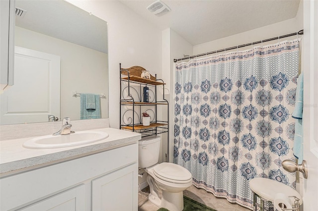 bathroom featuring vanity, walk in shower, toilet, tile patterned floors, and a textured ceiling