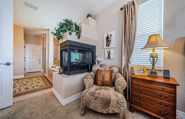 living area with light tile patterned floors and a fireplace