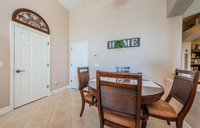 dining space featuring a high ceiling and light tile patterned flooring