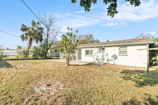 rear view of house with a patio and a yard