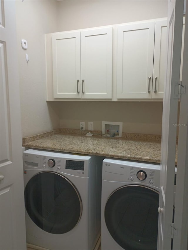 washroom with cabinets and washer and dryer