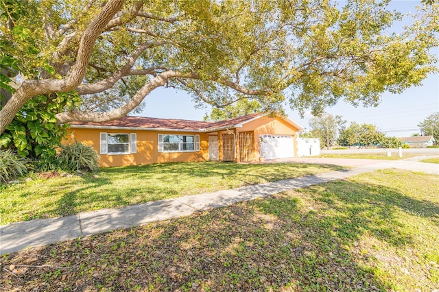 ranch-style home featuring a garage and a front lawn