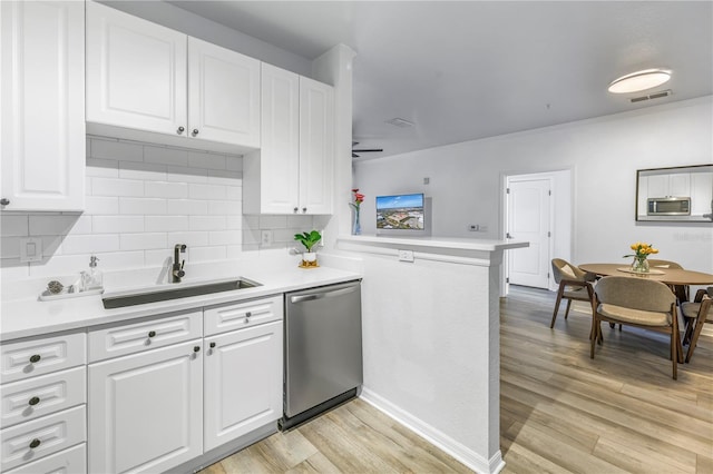 4221 W Spruce St Unit 1325, Tampa, FL 33607 - kitchen featuring sink, stainless steel appliances, light hardwood / wood-style floors, white cabinets, and kitchen peninsula