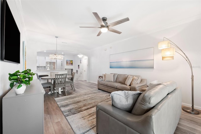 living room featuring crown molding, ceiling fan, and light hardwood / wood-style flooring