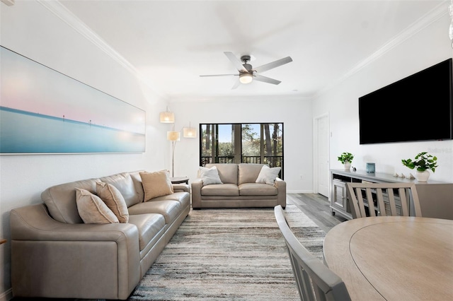 living room with crown molding, light hardwood / wood-style floors, and ceiling fan