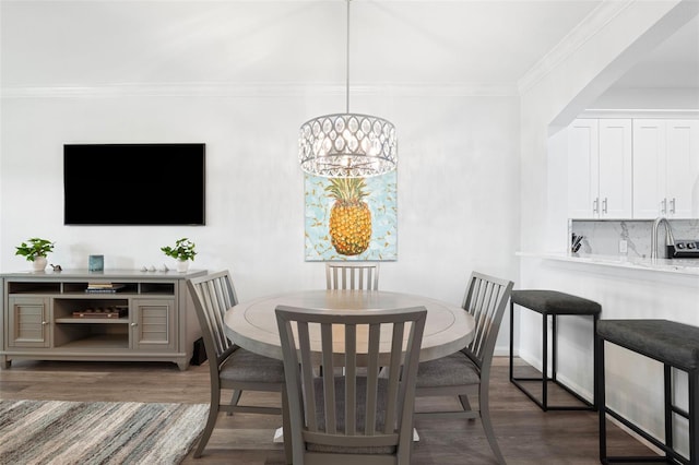 dining area featuring ornamental molding, dark hardwood / wood-style flooring, and a notable chandelier